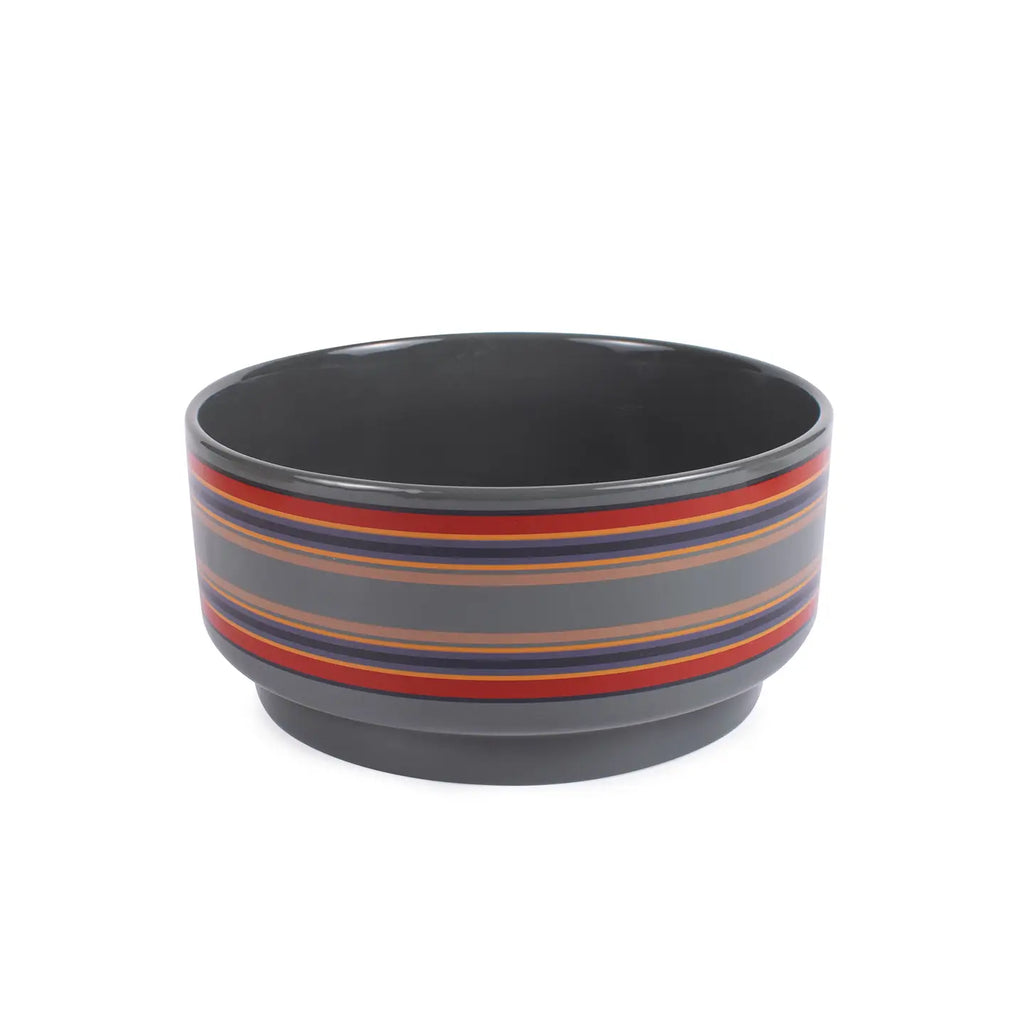 Gray dog bowl with red and blue stripes on a white background. Wagging Tails Pet Boutique